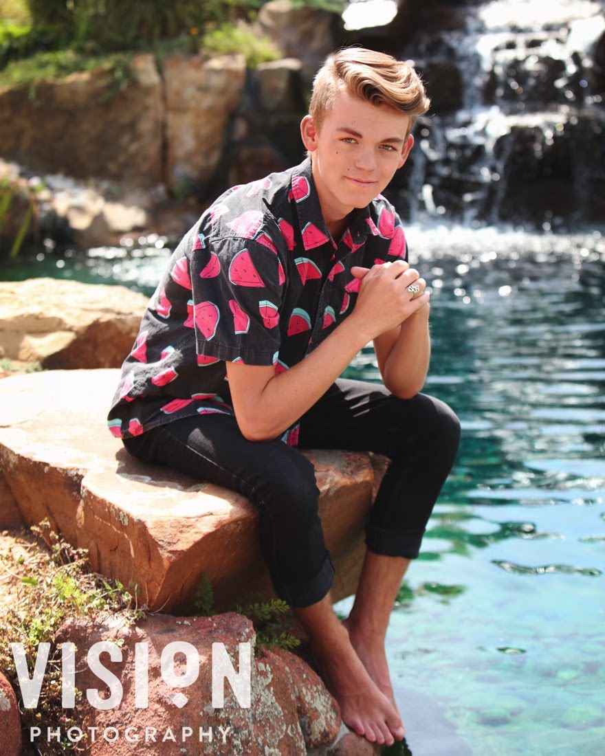 Photo of DJ Seth Lindsey sitting on a rock in front of a body of water